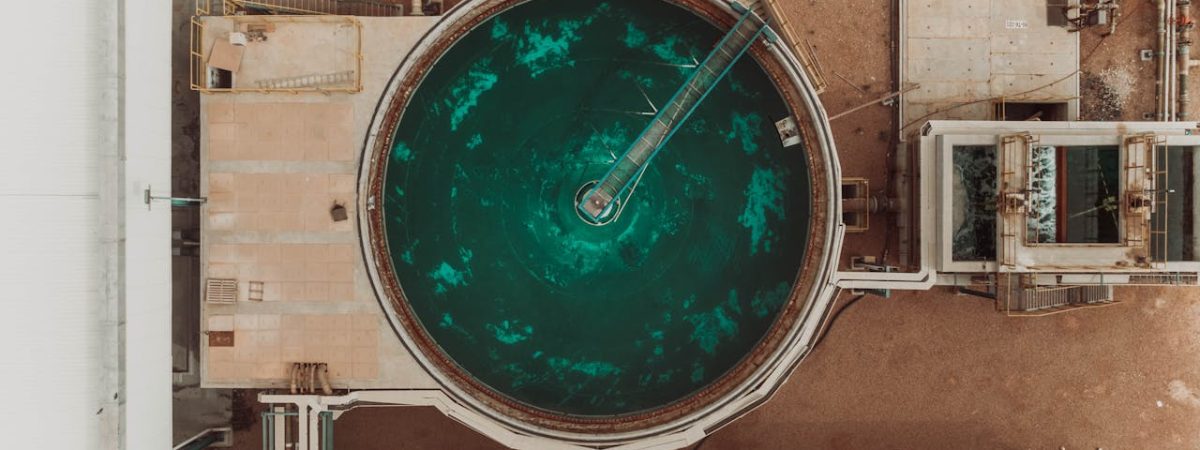 Drone view of a large circular water treatment tank at an industrial facility.